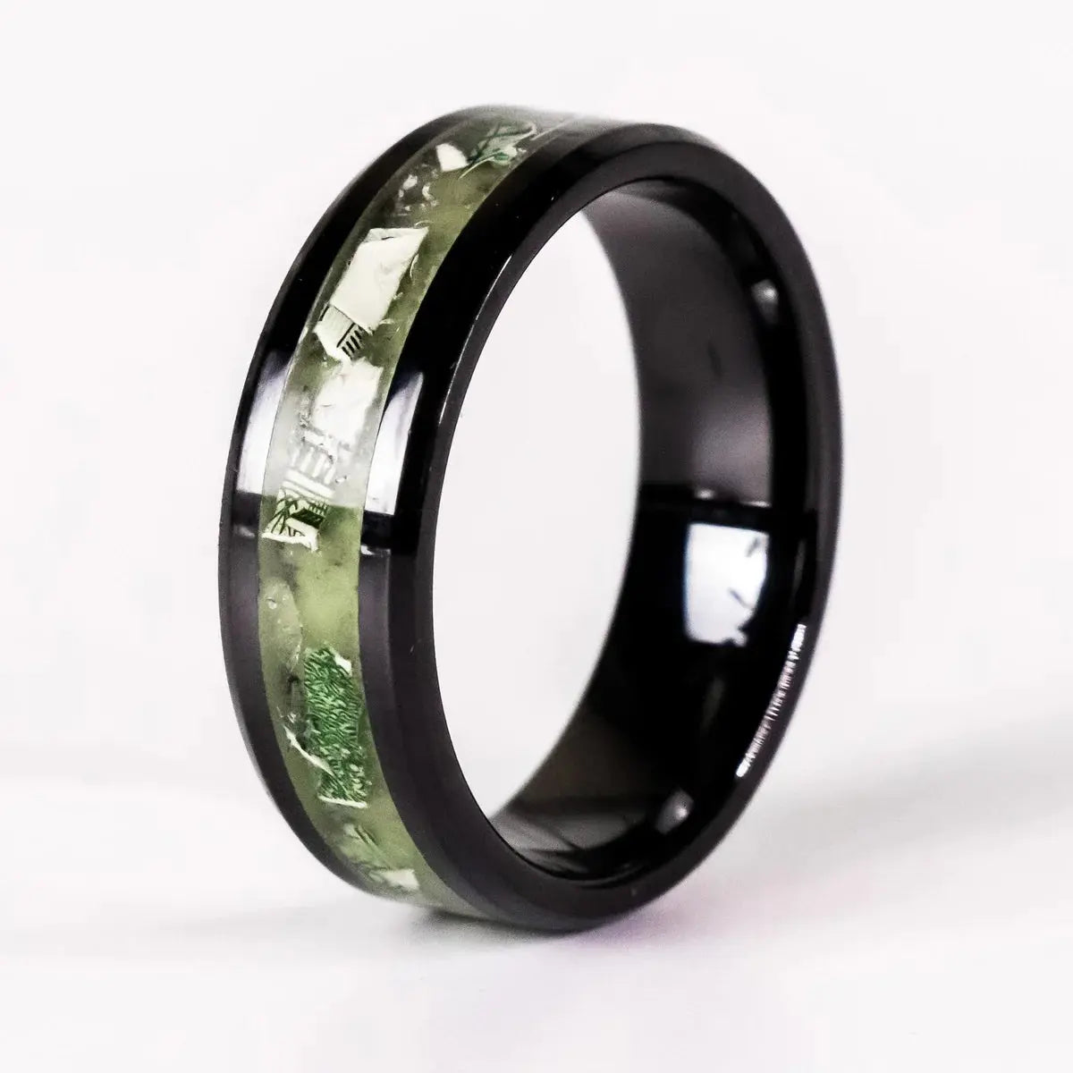 Black ring with green dollar bill inlay design on a white background