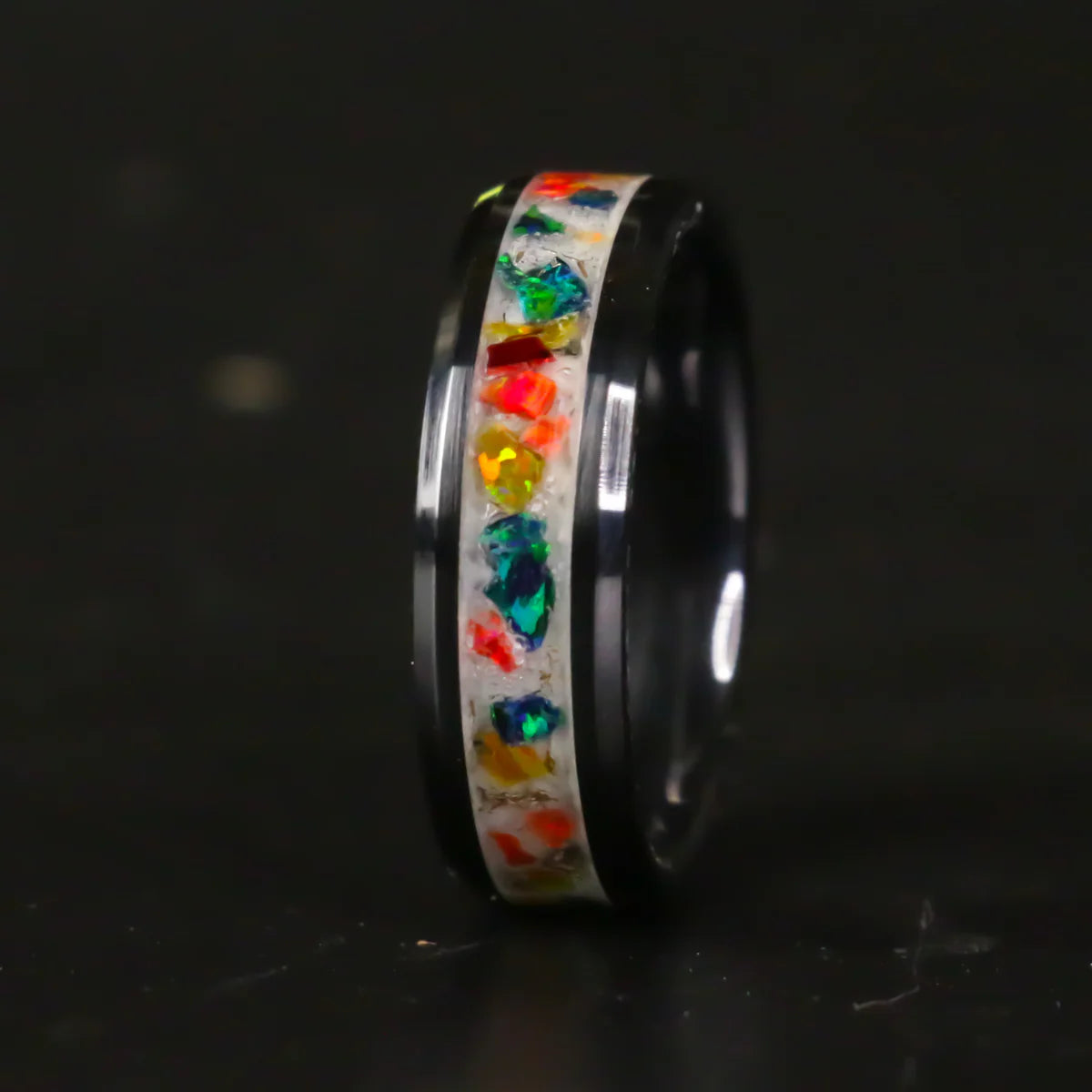 Tungsten Ring with colorful gemstones and colored powder inlay on a black background