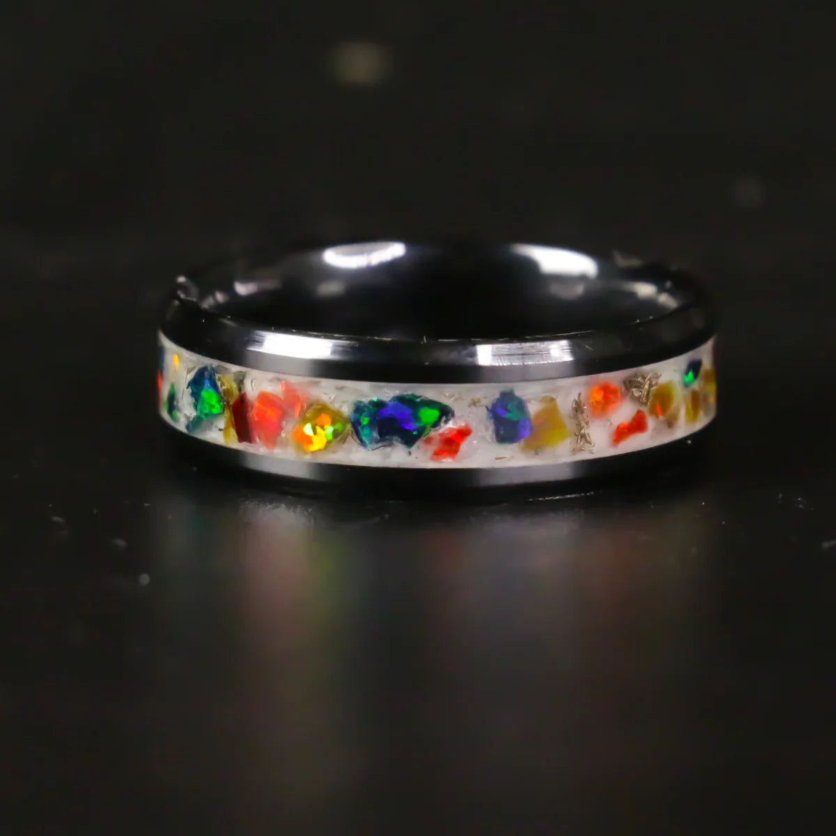 black ceramic Ring with colorful gemstones on a black background