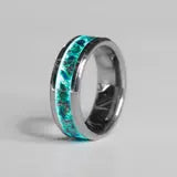Silver ring with turquoise inlay on a gray background