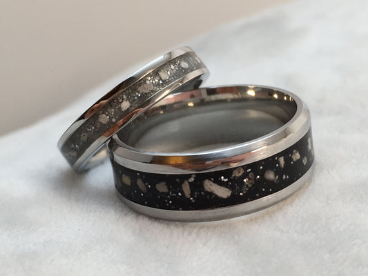 Two rings with metallic and speckled designs on a white surface