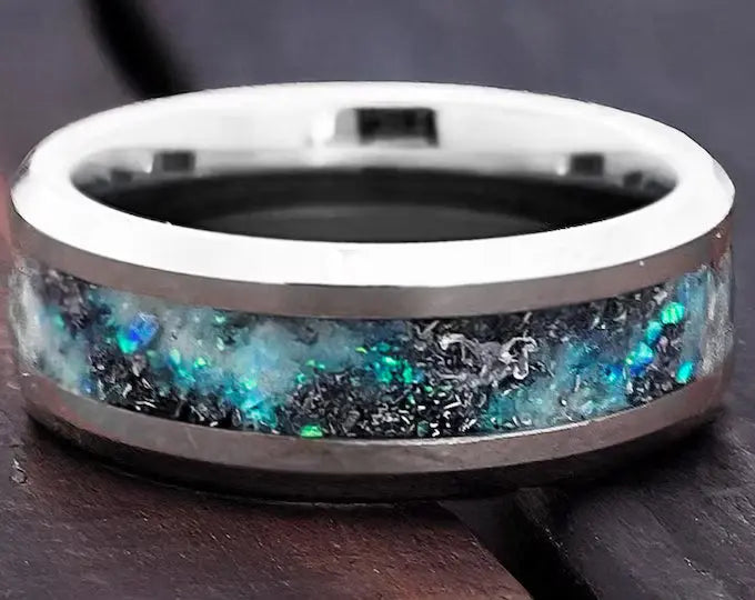 Silver ring with a colorful stone on a dark surface