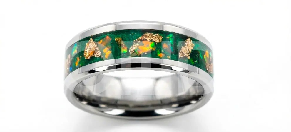 Silver ring with green and gold inlay on a white background
